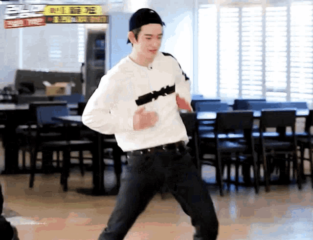 a man in a white shirt is dancing in a restaurant