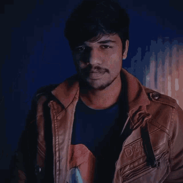 a man wearing a brown jacket with d & g on the sleeve