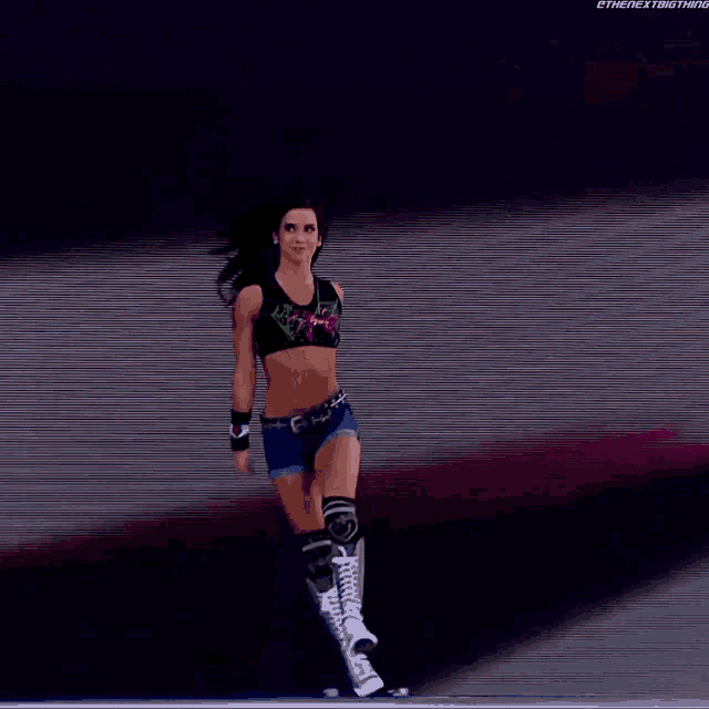 a woman in a crop top and shorts is walking in front of a screen that says " the next thing "