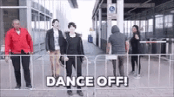 a group of people are standing in front of a fence with the words dance off written on the bottom .