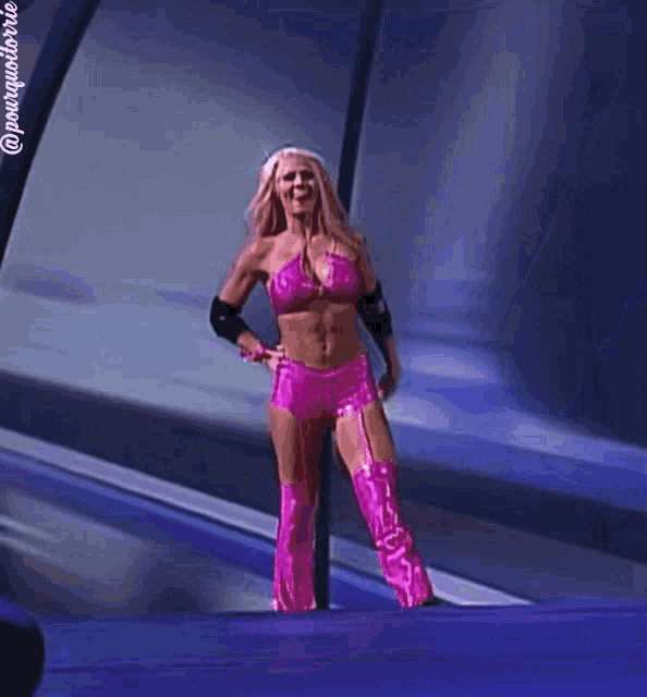 a woman in a pink outfit stands in front of a window