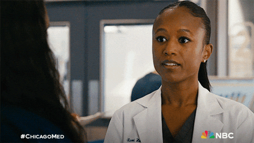 a woman in a lab coat is talking to another woman with nbc on the bottom right