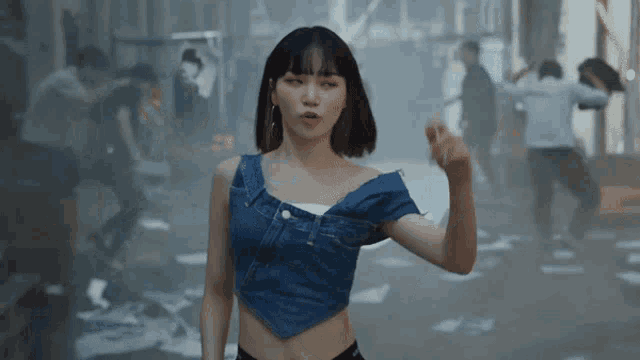 a woman in a denim crop top is pointing at something