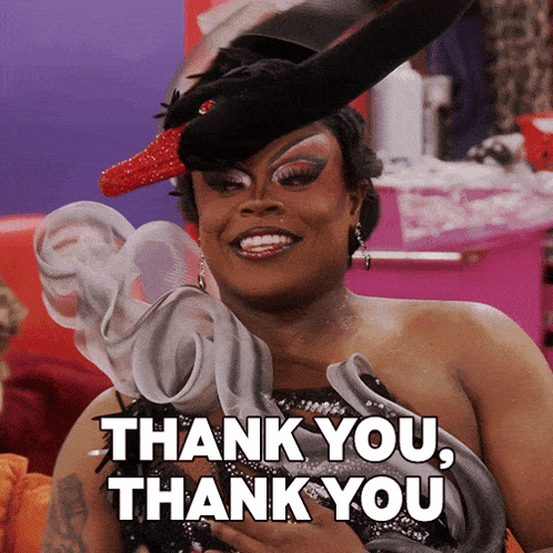 a woman wearing a swan hat says thank you