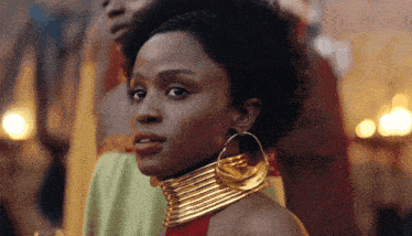 a close up of a woman wearing a gold necklace and hoop earrings
