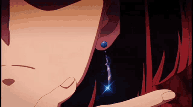a close up of a woman 's ear with a blue earring on it