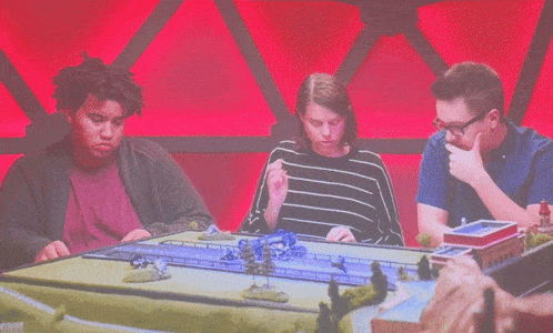 a man and two women are laughing while playing a game