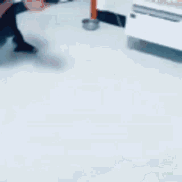 a blurred image of a room with a door and a box of milk on the floor .