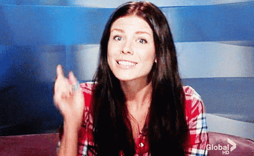 a woman in a plaid shirt is sitting on a couch and making a funny face