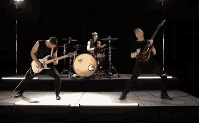 a group of people are playing instruments on a stage in a dark room .