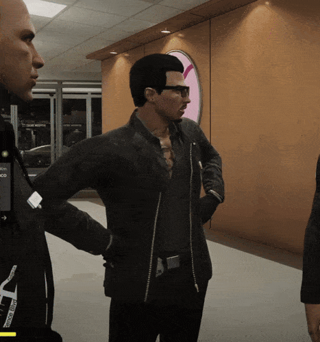 a man in a black jacket is standing next to a man in a black shirt and a man in a black jacket