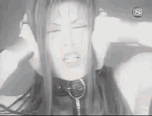 a black and white photo of a woman with her hands on her ears .