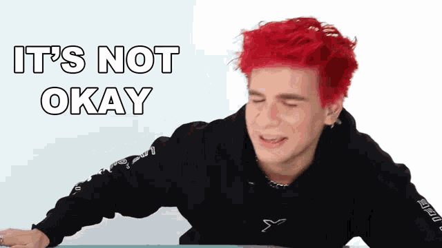 a man with red hair says it 's not okay while wearing a black hoodie