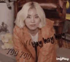 a woman with blonde hair is kneeling down and saying " hey hey hey "