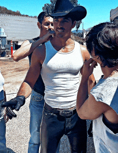 a man wearing a cowboy hat and a tank top