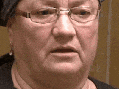 a close up of a woman wearing glasses and a scarf making a funny face .