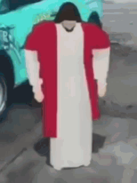 jesus is standing in front of a car wearing a red robe and a white robe .