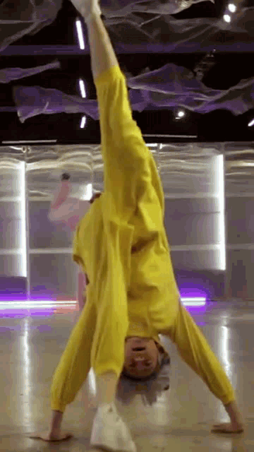 a person is doing a handstand in a dance studio .