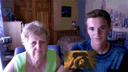 an elderly woman and a young man are looking at a picture