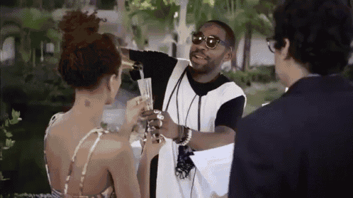 a man is pouring champagne into a glass while a woman looks on .