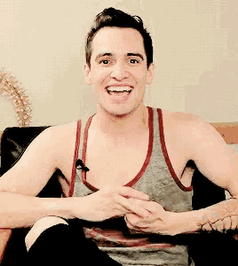 a man wearing a tank top with a microphone on it smiles