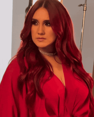 a woman with long red hair is wearing a choker