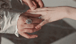 a man putting a wedding ring on a woman 's finger