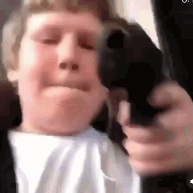 a man is holding a gun in his hand and making a funny face .
