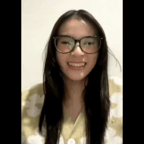 a woman with long hair and glasses is smiling .