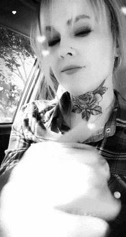 a woman with a tattoo of a rose on her neck is sitting in a car .