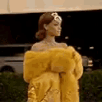 a woman is wearing a yellow dress and a crown .