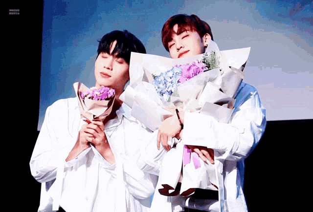 two young men holding bouquets of flowers one of which has the word flowers on it