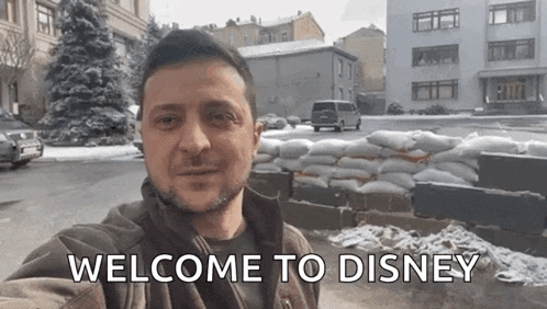 a man is taking a selfie with the words welcome to disney on the bottom .