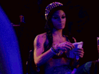 a woman with a crown on her head is holding a trophy