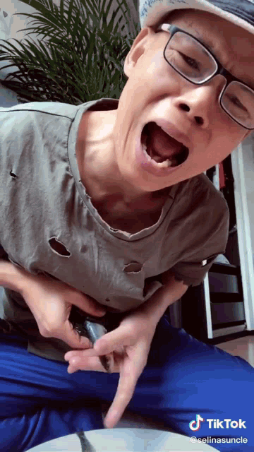 a man wearing glasses and a hat is making a funny face with tiktok written in the corner
