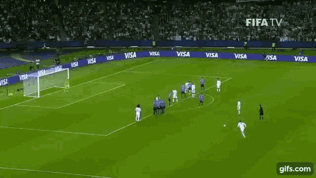 a soccer game is being played on a field sponsored by visa .