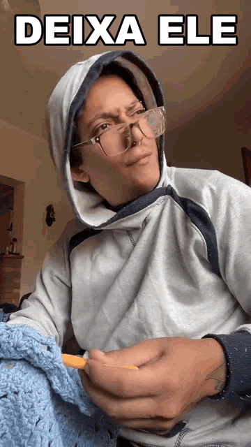 a man wearing glasses and a hoodie is holding a knitting needle and the words deixa ele above him