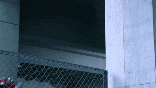 a chain link fence is surrounding a concrete wall