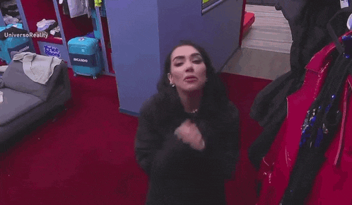a woman in a black sweater is standing in a dressing room .