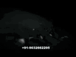 a black and white photo of a person 's hands with a phone number visible
