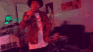 a man is dancing in a room with a sign that says music on it