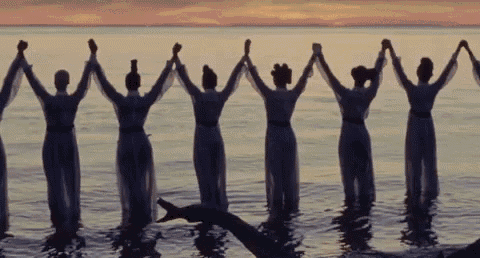 a group of women holding hands in the water