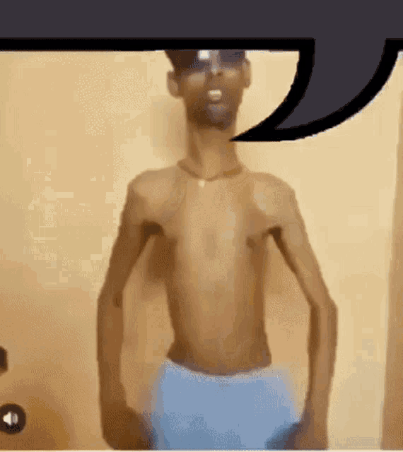 a shirtless man wearing sunglasses and blue shorts is standing in front of a wall .