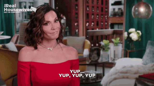 a woman in a red off the shoulder top says yup
