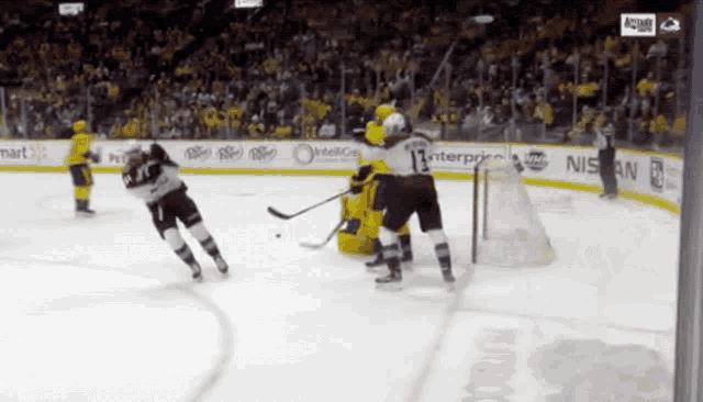 a hockey game is being played in a stadium with advertisements for nissan