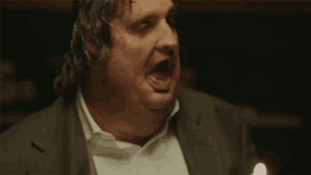 a man in a suit and white shirt making a funny face