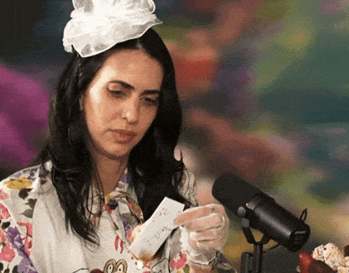 a woman wearing a white hat and gloves is holding a piece of paper that says ' i love you ' on it