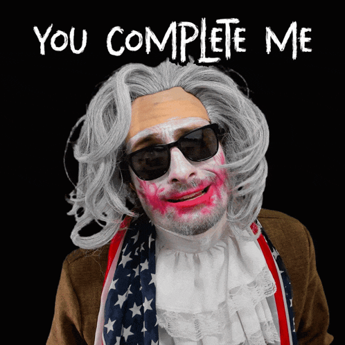 a man in a wig and sunglasses says " you complete me " on a black background