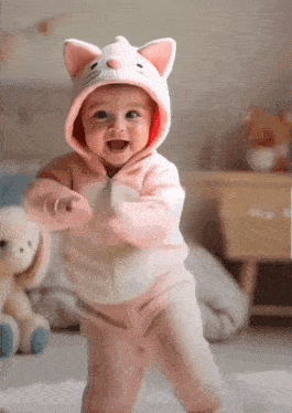a baby dressed in a cat costume is dancing