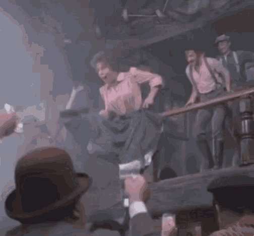 a group of people are dancing in a dark room with smoke coming out of it .